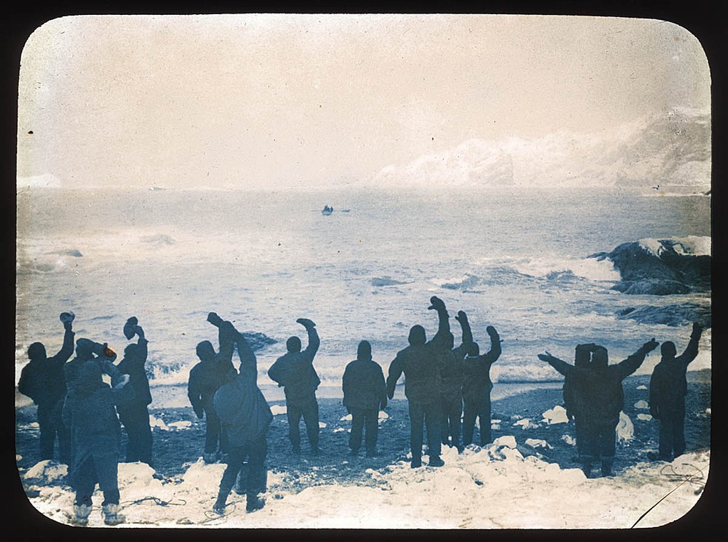 Elephant Island party waving goodbye to boat across Arctic sea